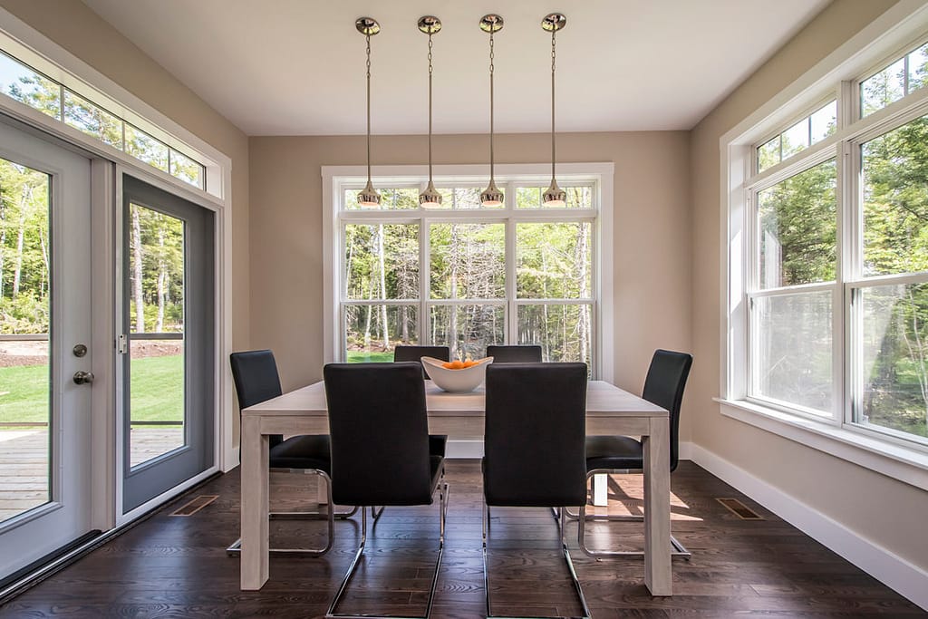 Dining room with wrap around double hung windows and a swinging glass door to the patio